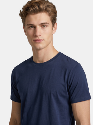 Man wearing a navy blue t-shirt against a light gray background
