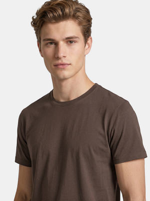 Man wearing a brown t-shirt against a plain background